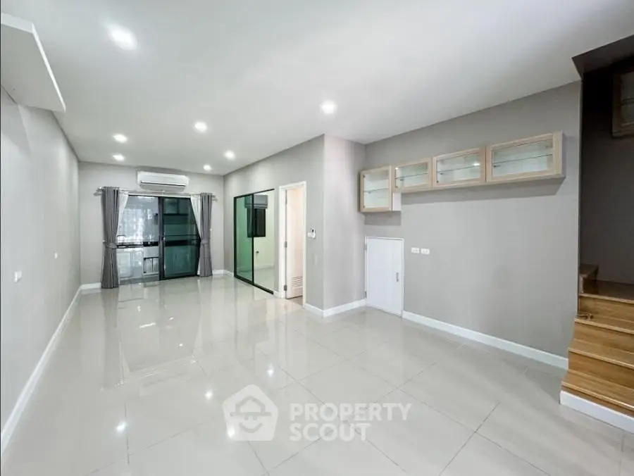 Spacious modern living room with sleek tile flooring and built-in storage
