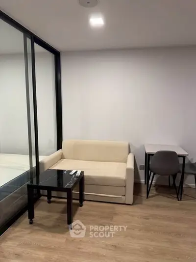 Modern living room with sleek glass partition and cozy seating area