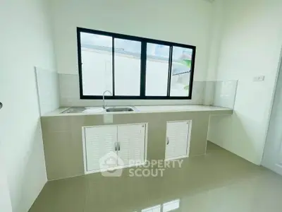 Modern kitchen with sleek cabinetry and large window for natural light