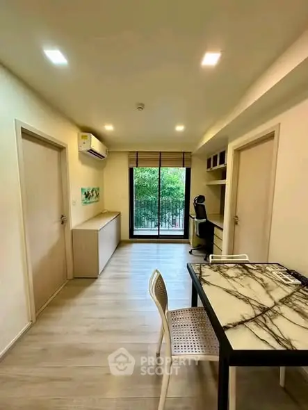 Modern living room with marble table and balcony view, featuring sleek design and natural light.