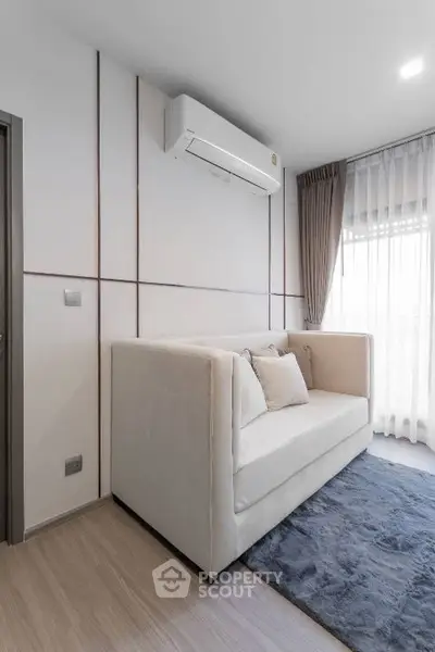 Modern living room with cozy sofa and air conditioning, featuring elegant curtains and soft lighting.