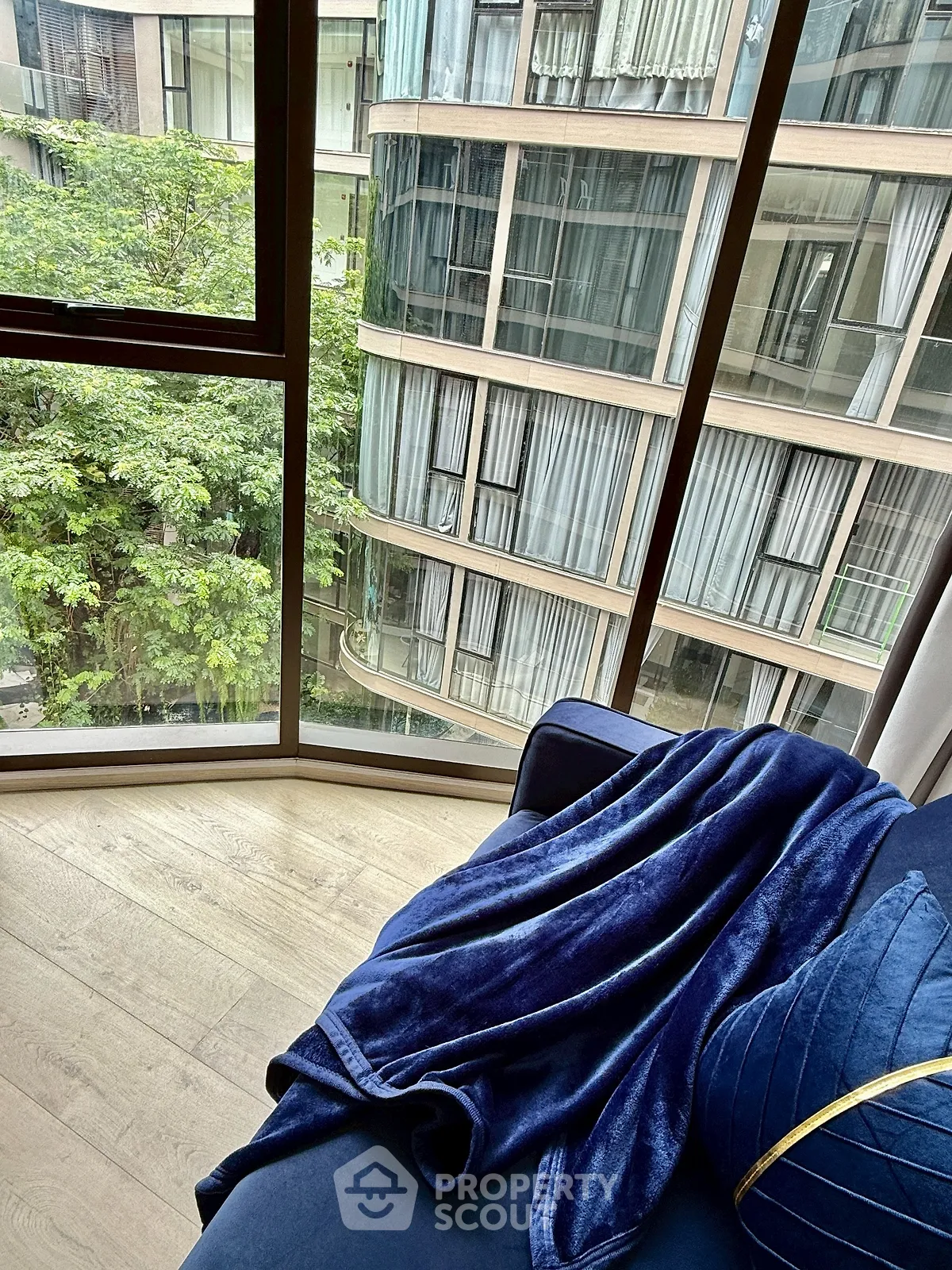 Luxurious apartment with floor-to-ceiling windows offering stunning city views and elegant interior design.