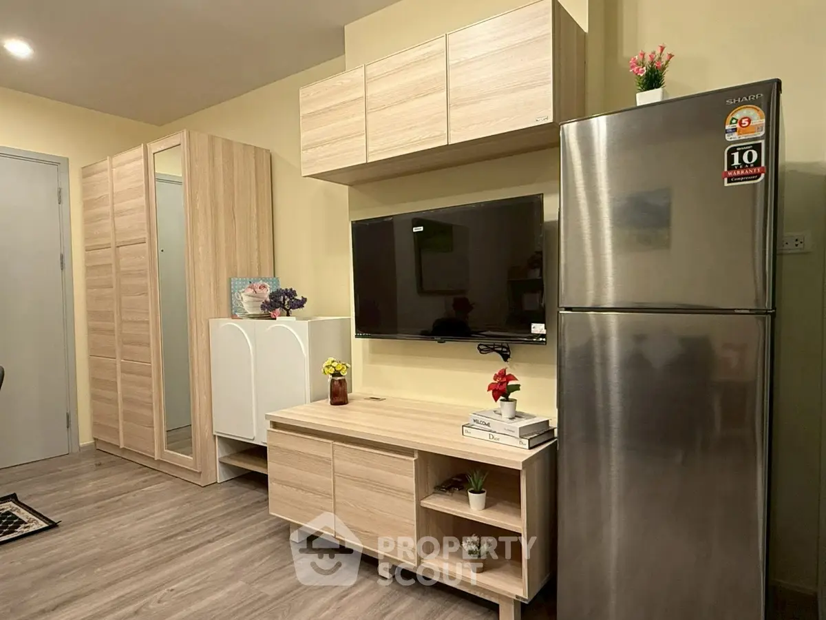 Modern living room with sleek wooden furniture and stainless steel fridge