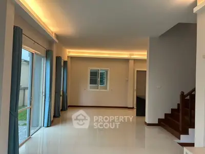 Spacious modern living room with natural light and elegant staircase