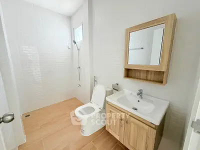 Modern bathroom with wooden accents and sleek white tiles