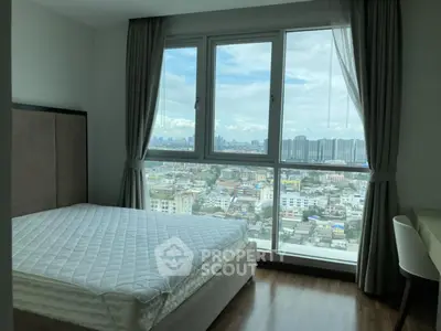 Spacious bedroom with stunning city view from large windows, modern decor and natural light.
