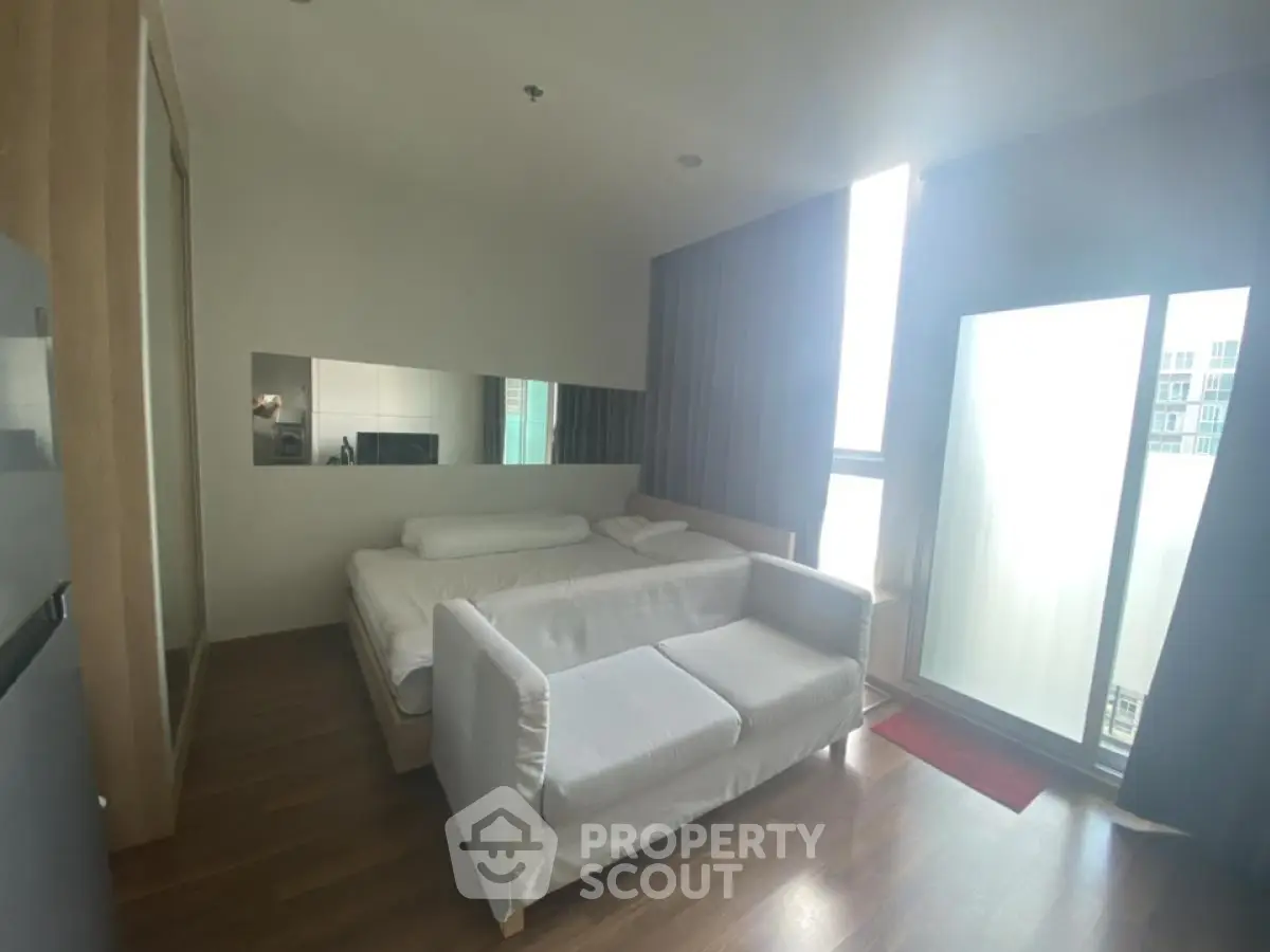 Modern bedroom with large window and cozy sofa in a stylish apartment