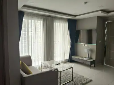 Modern living room with large windows and stylish decor in a high-rise apartment.