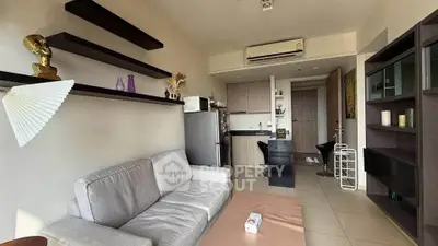 Modern living room with sleek shelves and compact kitchen in open layout apartment.