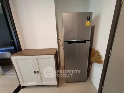 Modern kitchen corner with sleek fridge and storage cabinet