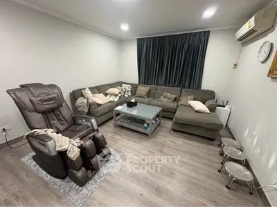 Spacious living room with cozy sectional sofa and massage chair