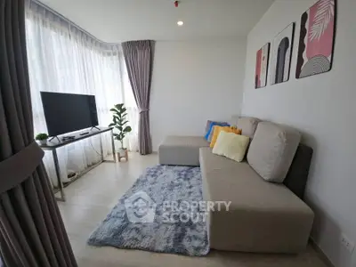 Modern living room with cozy sofa, stylish decor, and large windows for natural light.
