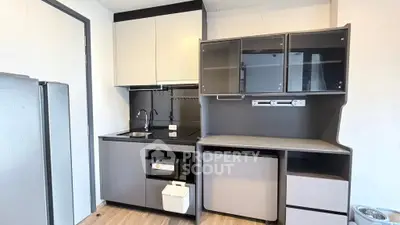 Modern compact kitchen with sleek cabinetry and built-in appliances in a stylish apartment.