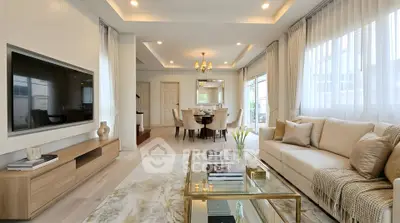 Luxurious living room with elegant decor and spacious layout, featuring a large TV and stylish furniture.