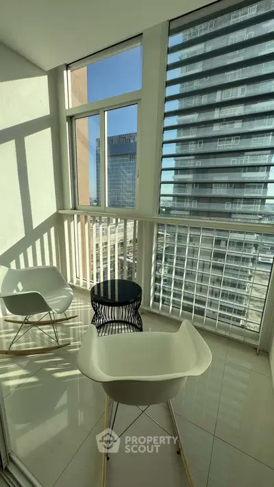 Modern balcony with stylish chairs and city view, perfect for relaxation and enjoying urban living.