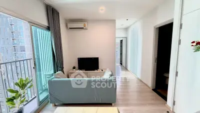 Modern living room with balcony in a stylish apartment, featuring sleek furniture and natural light.