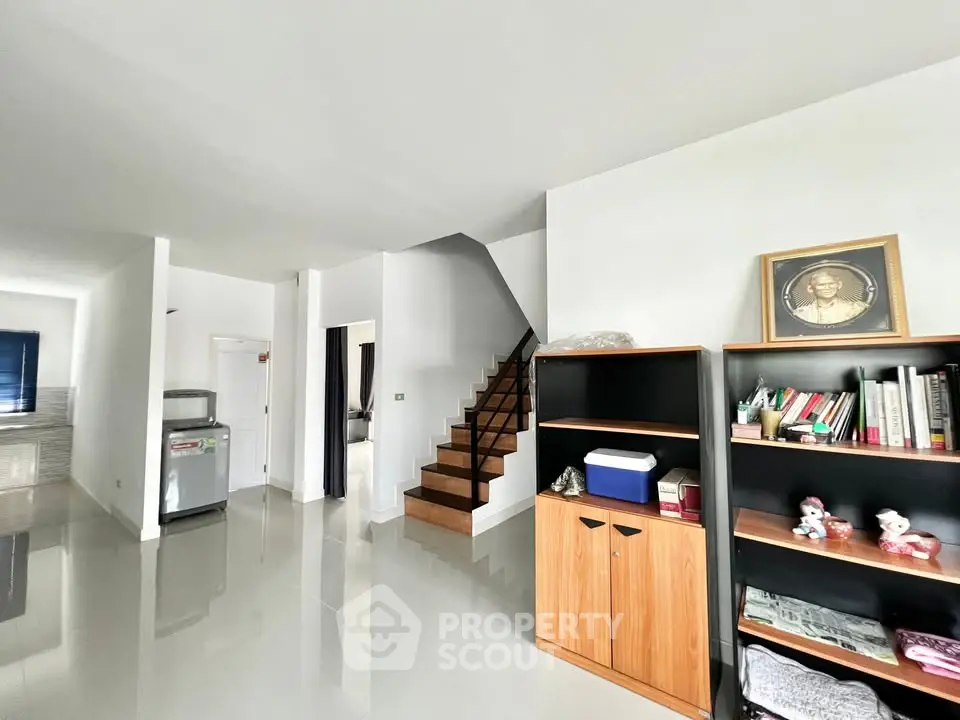 Spacious modern living area with sleek staircase and stylish shelving