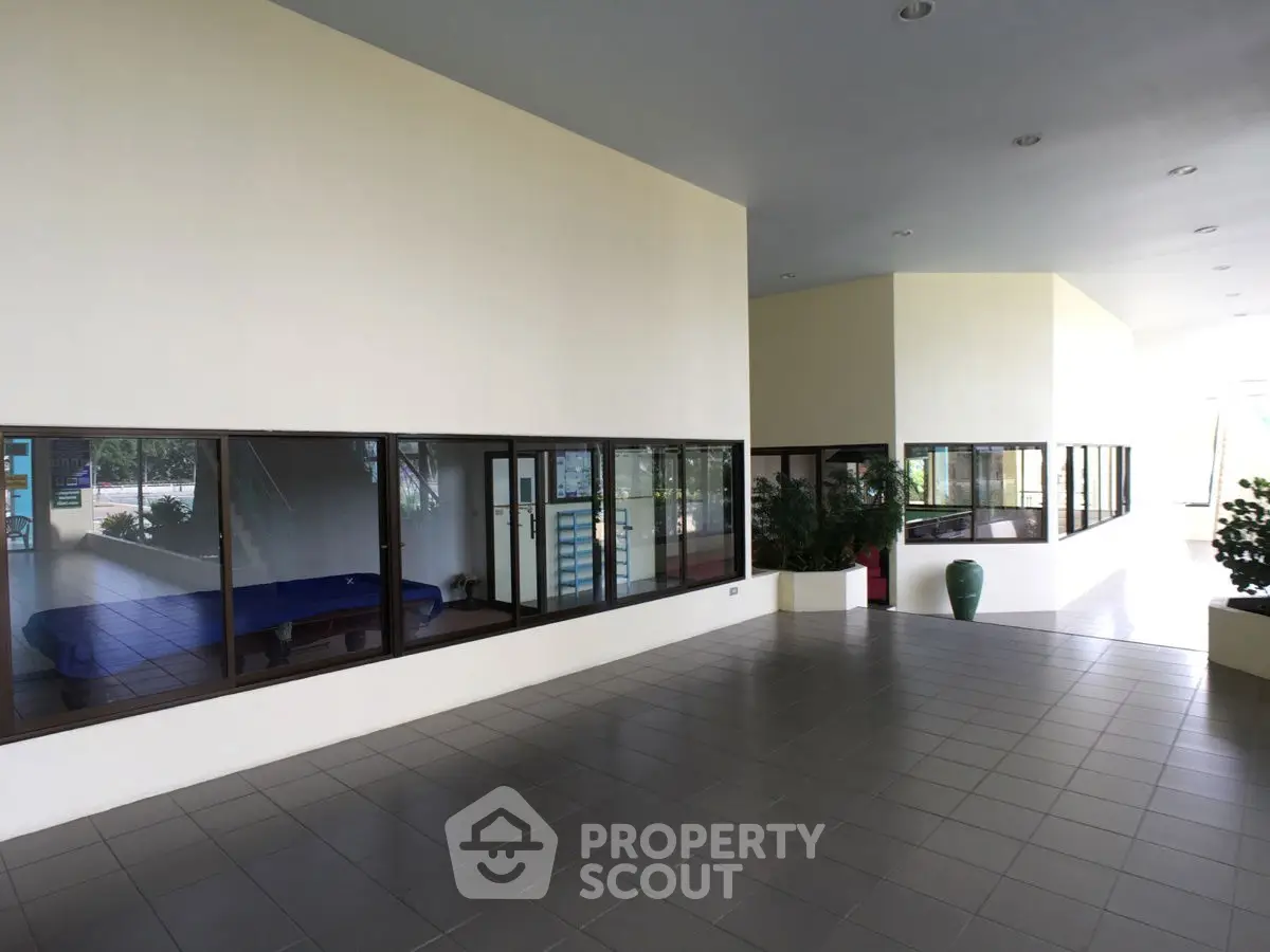 Spacious modern building entrance with large windows and tiled flooring