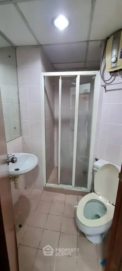 Compact bathroom with shower cabin and modern fixtures in a real estate property.