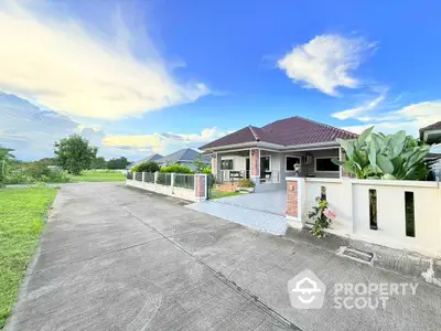 Charming single-story home with spacious driveway and lush greenery, perfect for serene living.