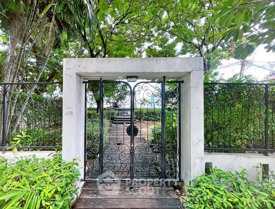 Charming garden entrance with wrought iron gate and lush greenery