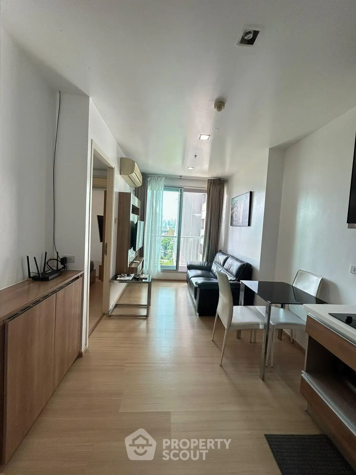 Modern living room with sleek furniture and balcony view in a stylish apartment.