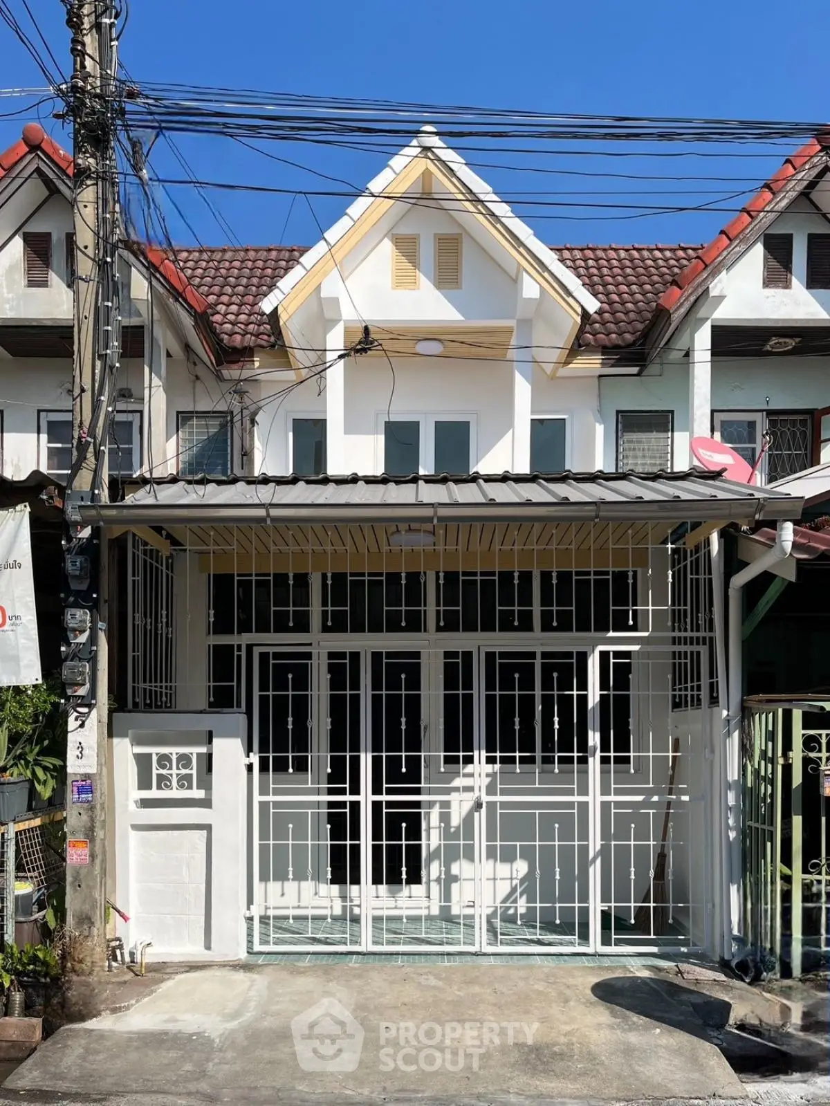 Charming townhouse exterior with gated entrance and classic roof design