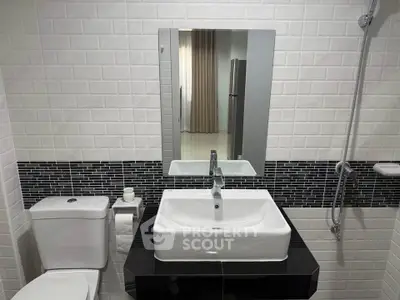 Modern bathroom with sleek sink and stylish black and white tiles