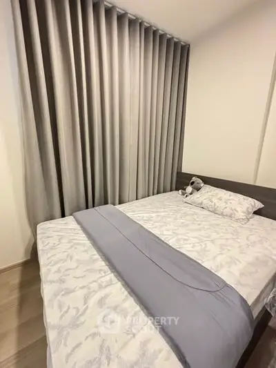 Cozy bedroom with elegant curtains and plush bedding, perfect for relaxation and comfort.