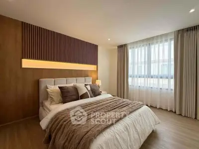 Luxurious bedroom with modern design, featuring a cozy bed, elegant lighting, and large window for natural light.