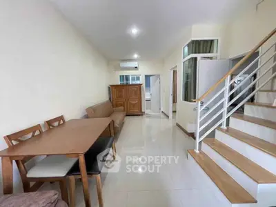 Spacious living room with dining area and staircase in modern home