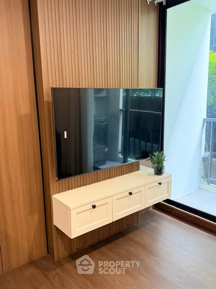 Modern living room with wall-mounted TV and sleek wooden paneling