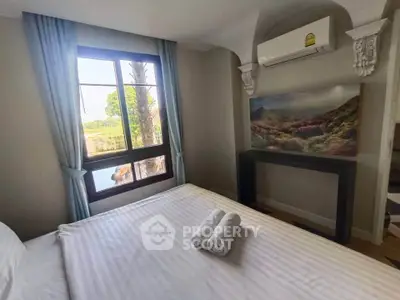 Cozy bedroom with scenic window view and air conditioning, perfect for relaxation.