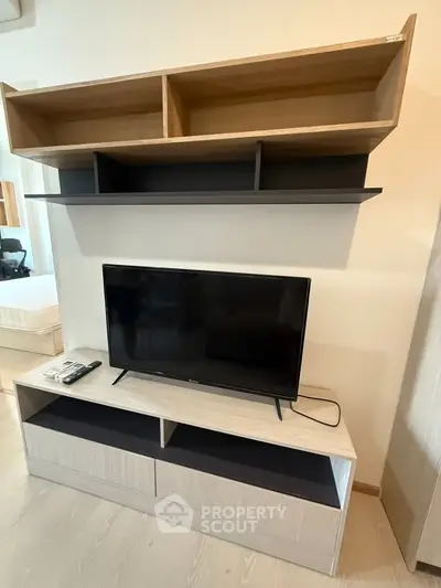 Modern living room with sleek TV stand and wall-mounted shelves, perfect for stylish urban living.