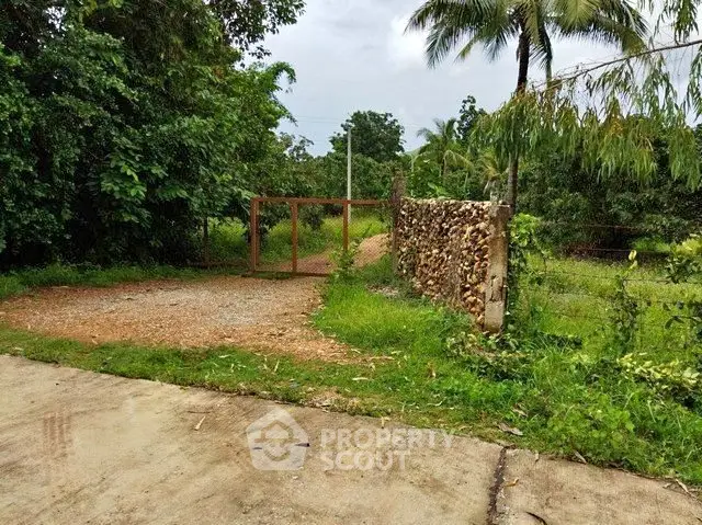 Charming rural property entrance with lush greenery and rustic gate