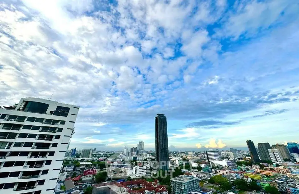 Stunning cityscape view from a high-rise building showcasing urban skyline and expansive sky.