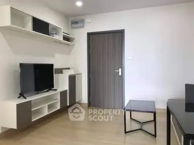 Modern living room with sleek furniture and wall-mounted TV in a stylish apartment.
