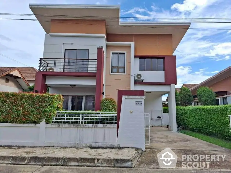 Modern two-story house with unique architecture and lush greenery in a serene neighborhood.