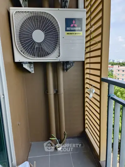 Compact balcony with air conditioning unit and city view, ideal for urban living.