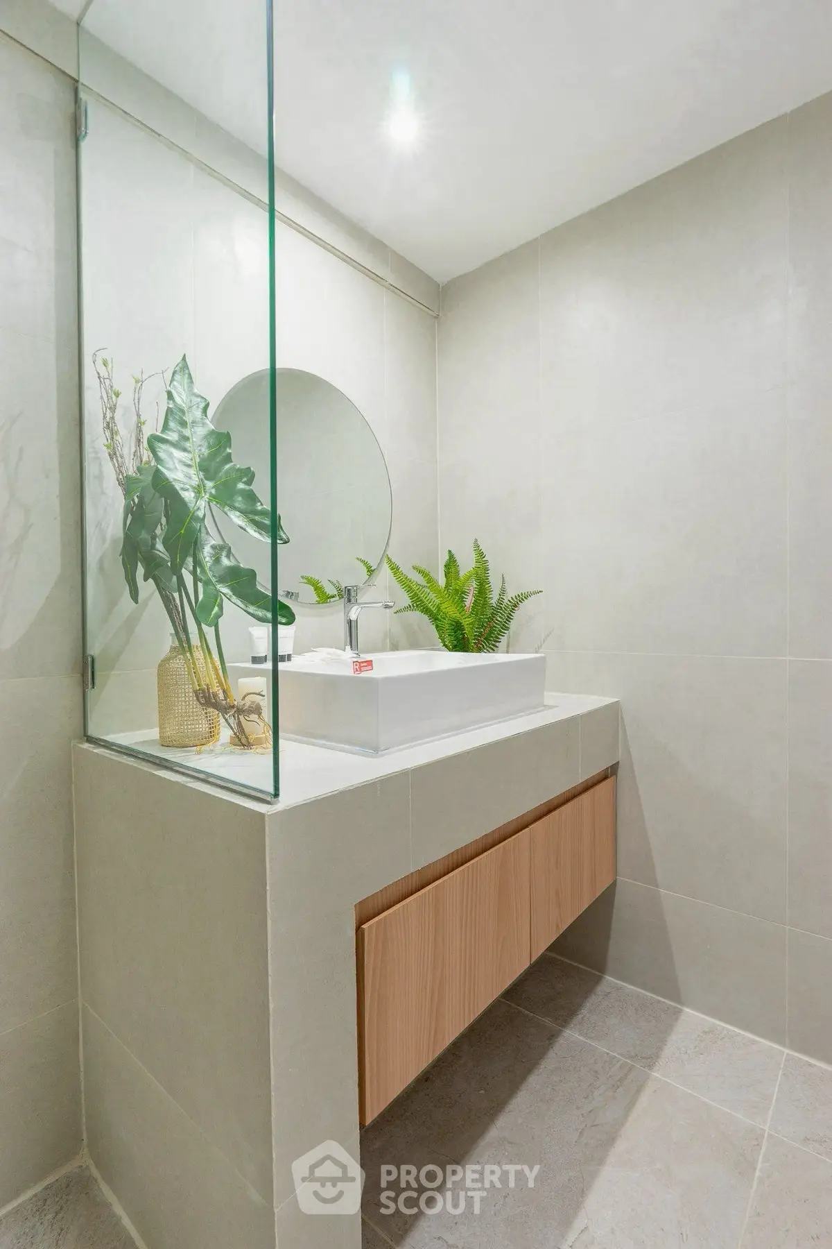 Modern bathroom with sleek design, featuring a stylish vanity and elegant plants for a refreshing ambiance.