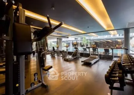Modern gym with state-of-the-art equipment and large windows overlooking a pool area.