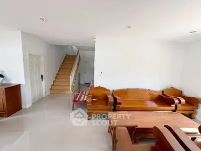 Spacious living room with wooden furniture and staircase in modern home