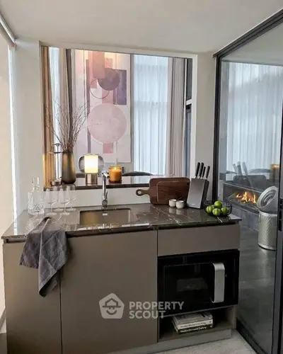 Modern kitchen with sleek design, featuring a marble countertop, built-in microwave, and stylish decor.