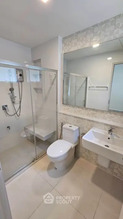 Modern bathroom with glass shower and sleek fixtures in contemporary home