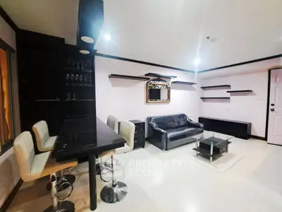 Modern living room with sleek black furniture and stylish shelving