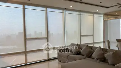 Luxurious living room with panoramic city view and elegant furnishings.