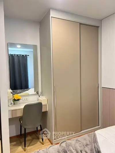 Cozy bedroom with built-in wardrobe and vanity desk, perfect for modern living.