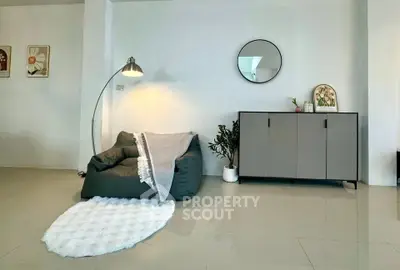 Modern living room with cozy armchair, stylish cabinet, and elegant decor.