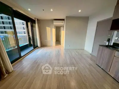 Spacious modern living room with large windows and balcony access in a stylish apartment.