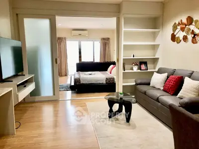 Stylish living room with modern decor and open view to bedroom